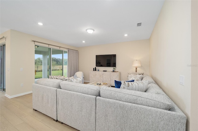 living room with recessed lighting, visible vents, baseboards, and light wood-style flooring