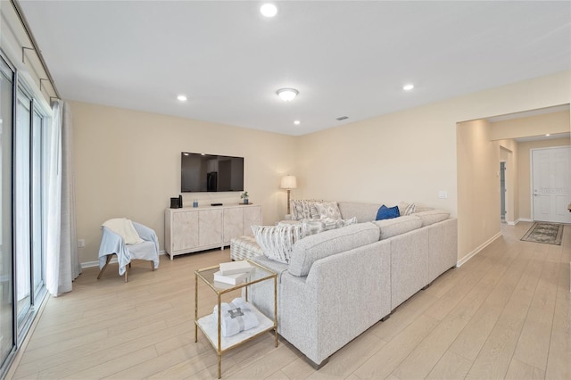 living area with recessed lighting, baseboards, and light wood finished floors