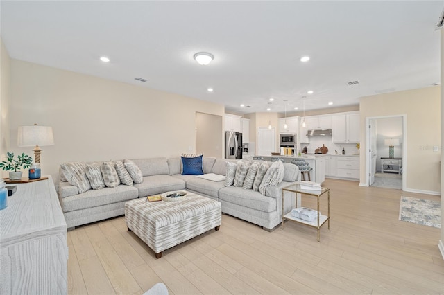 living area featuring visible vents, recessed lighting, and light wood-style floors