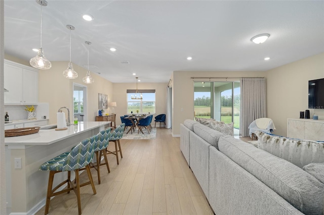 living room with recessed lighting, light wood-type flooring, and baseboards