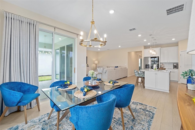 dining space featuring light wood-type flooring, visible vents, a chandelier, and recessed lighting