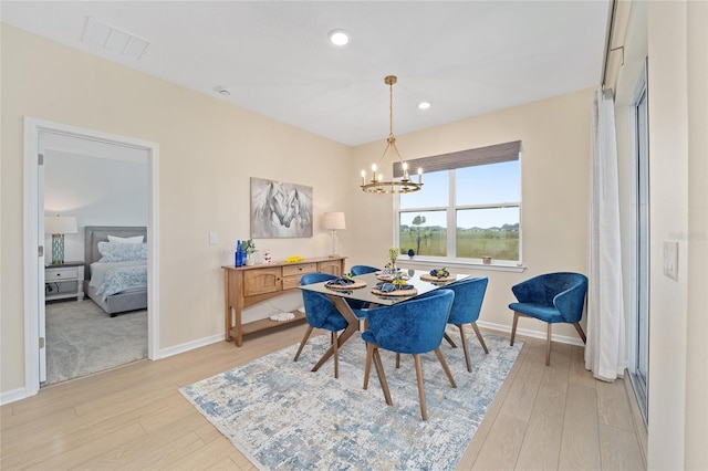 dining space featuring visible vents, baseboards, light wood-style floors, and a chandelier