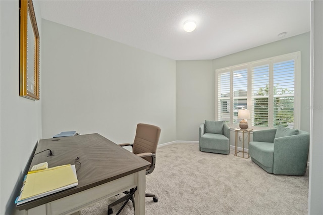 carpeted office with a textured ceiling and baseboards