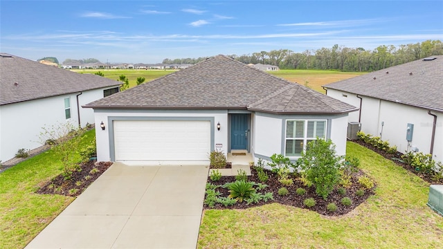 ranch-style house with a shingled roof, concrete driveway, a front yard, cooling unit, and an attached garage