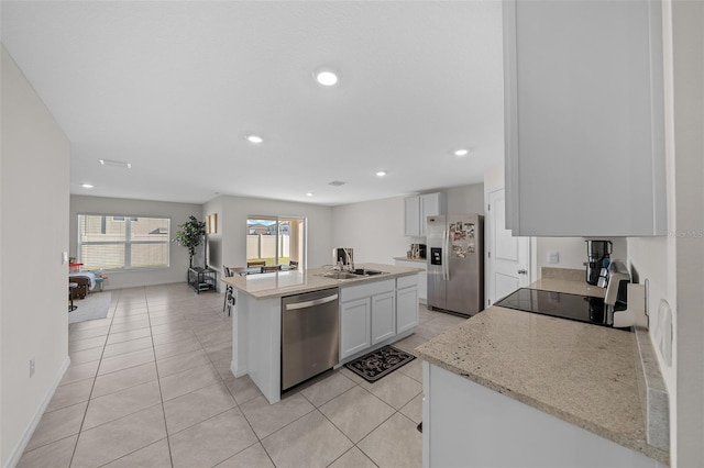 4931 SW 88th Pl, Ocala, FL 34476 - kitchen featuring a center island with sink, light tile patterned flooring, recessed lighting, appliances with stainless steel finishes, and white cabinetry