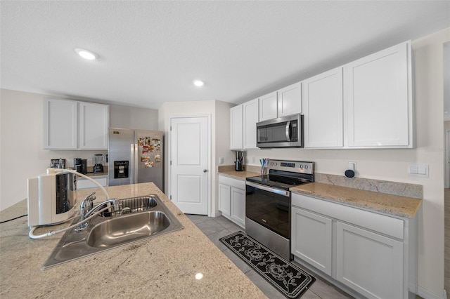 4931 SW 88th Pl, Ocala, FL 34476 - kitchen featuring white cabinets, stainless steel appliances, light countertops, and a sink