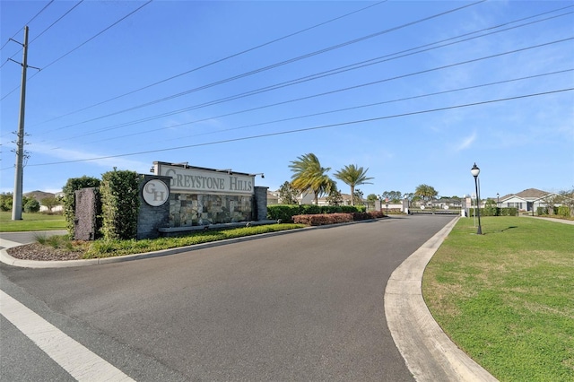 4931 SW 88th Pl, Ocala, FL 34476 - view of road featuring a gated entry, curbs, and street lighting