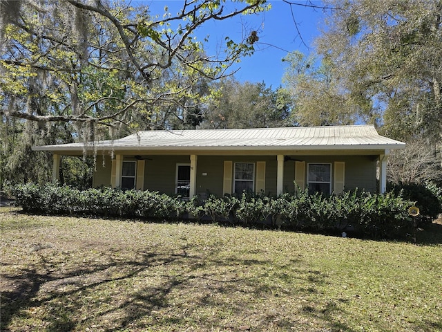 view of front of home with metal roof and a front lawn