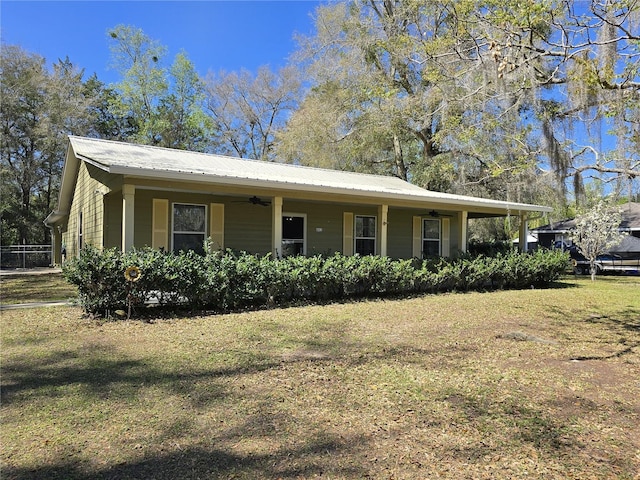 view of front of home with metal roof, a ceiling fan, and a front yard