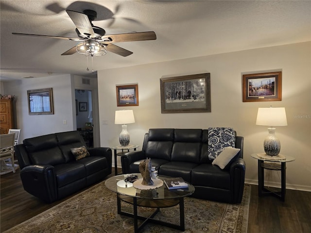 living area with a ceiling fan, wood finished floors, visible vents, and baseboards