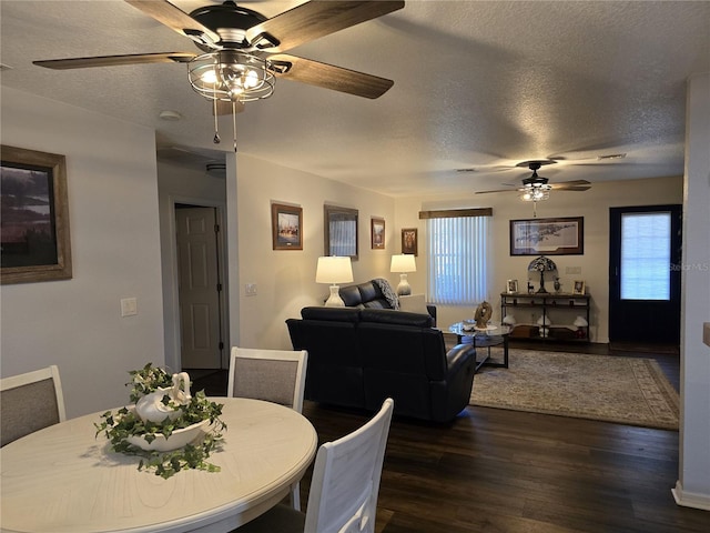 dining space featuring dark wood-style flooring and a textured ceiling