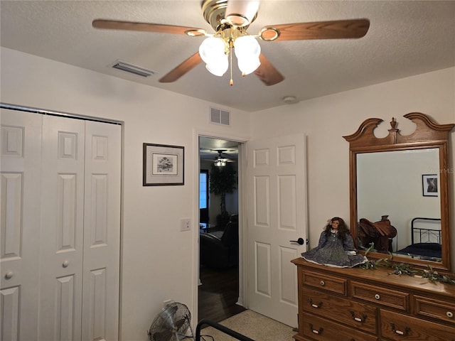 bedroom featuring visible vents, a textured ceiling, and a closet