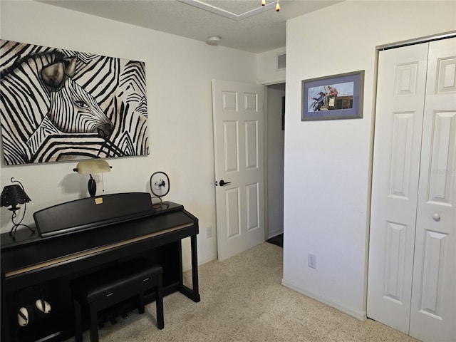 sitting room featuring visible vents, baseboards, and a textured ceiling