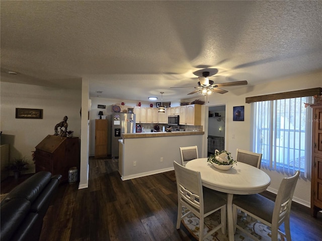 dining area with ceiling fan, baseboards, dark wood-style flooring, and a textured ceiling