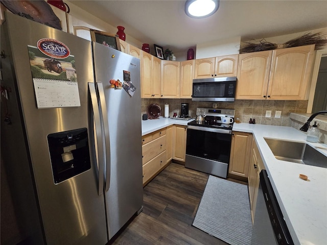 kitchen with tasteful backsplash, dark wood-type flooring, light brown cabinetry, stainless steel appliances, and a sink