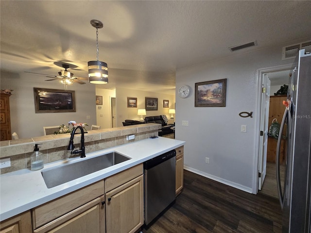 kitchen featuring visible vents, open floor plan, light countertops, appliances with stainless steel finishes, and a sink