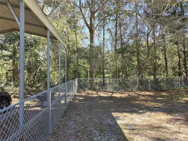 view of yard with a fenced backyard and a view of trees