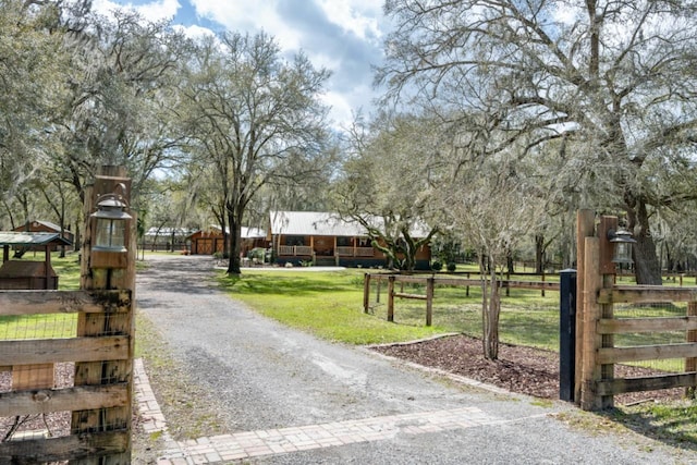 view of road with a gated entry and gravel driveway