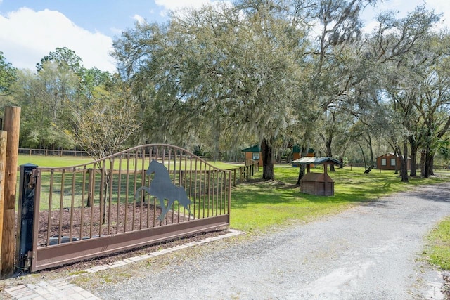 view of gate with a yard and fence