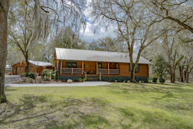 log-style house with log exterior, a porch, metal roof, and a front lawn