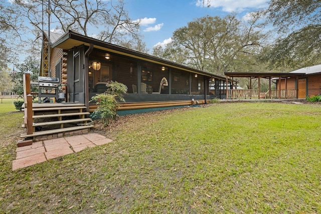 rear view of house featuring log siding, a yard, and a sunroom