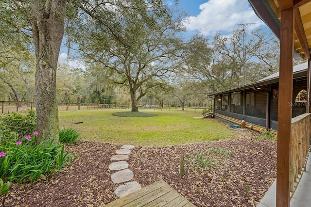 view of yard with fence and a sunroom