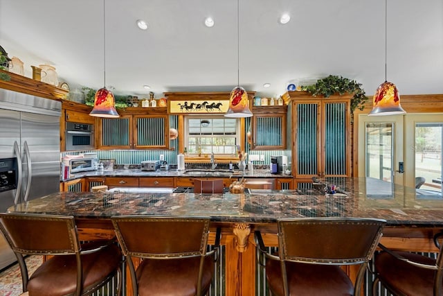 kitchen with a kitchen bar, recessed lighting, appliances with stainless steel finishes, and a sink