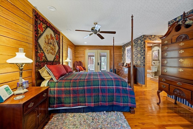 bedroom featuring a ceiling fan, access to outside, a textured ceiling, wood finished floors, and french doors