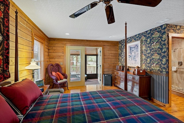 bedroom with a ceiling fan, wood finished floors, visible vents, a textured ceiling, and access to outside