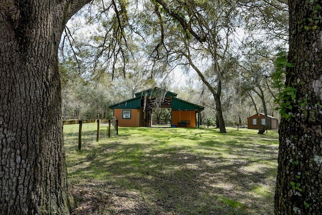 view of yard with an outbuilding and fence