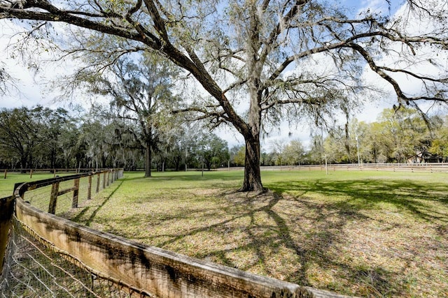 view of yard with a rural view and fence