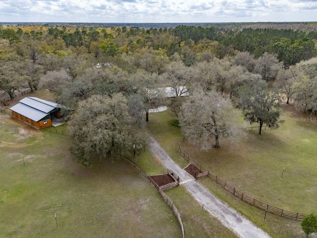 birds eye view of property featuring a rural view and a wooded view