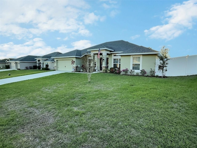 view of front of house with fence, a front yard, stucco siding, a garage, and driveway