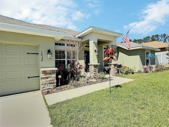 view of front of house featuring a front yard, a garage, stone siding, and stucco siding