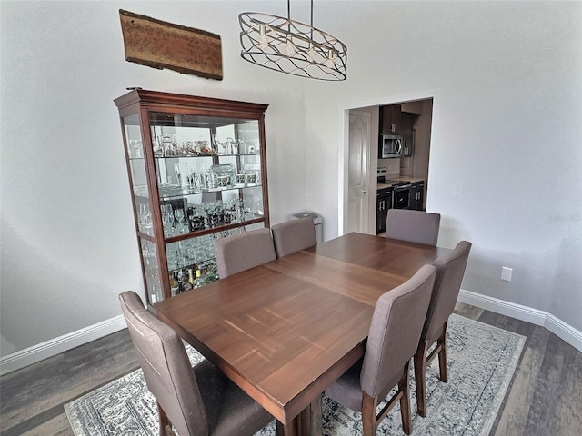 dining area with dark wood-style floors and baseboards