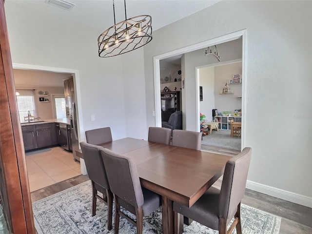 dining space with visible vents, baseboards, and light wood finished floors