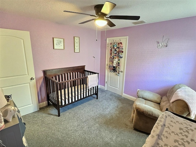 bedroom featuring visible vents, baseboards, carpet floors, a textured ceiling, and a ceiling fan