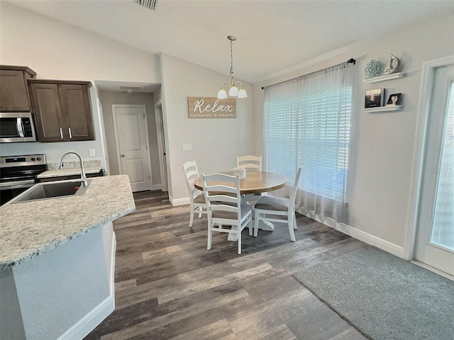 dining room with visible vents, a notable chandelier, lofted ceiling, dark wood finished floors, and baseboards