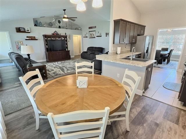 dining room with a ceiling fan, light wood-type flooring, and lofted ceiling