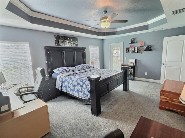 carpeted bedroom with visible vents, a textured ceiling, a raised ceiling, and baseboards