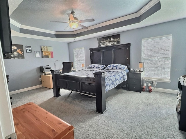 carpeted bedroom with ceiling fan, a raised ceiling, baseboards, and a textured ceiling