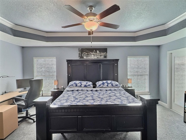 bedroom with baseboards, light colored carpet, a textured ceiling, a raised ceiling, and a ceiling fan