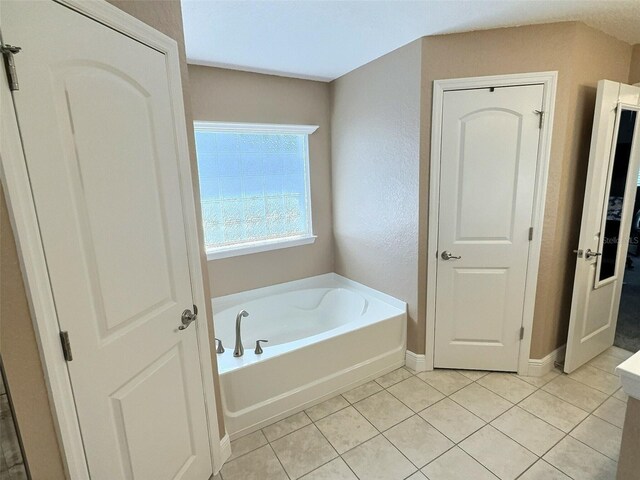 1034 SE 65th Cir, Ocala, FL 34472 - bathroom featuring a garden tub and tile patterned floors
