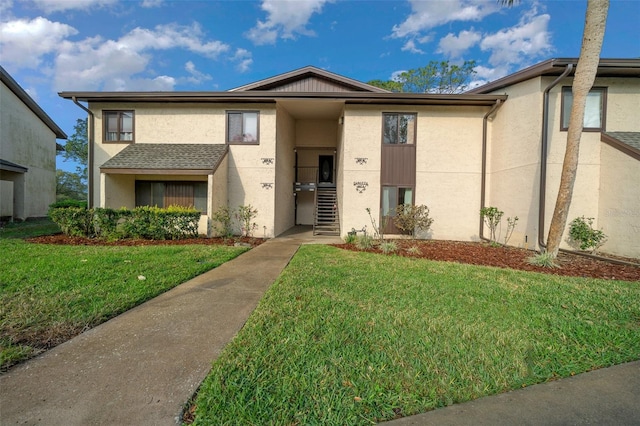 view of front of home featuring stucco siding and a front lawn