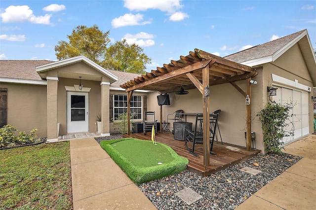 exterior space featuring roof with shingles, an attached garage, a pergola, stucco siding, and a deck