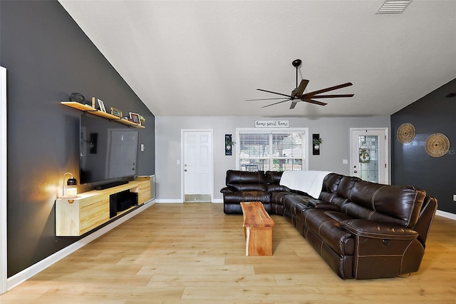 living room with visible vents, light wood-style flooring, baseboards, ceiling fan, and vaulted ceiling