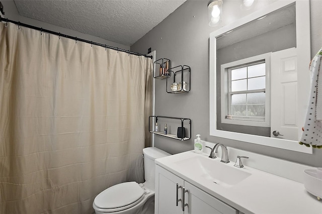 bathroom with toilet, vanity, and a textured ceiling