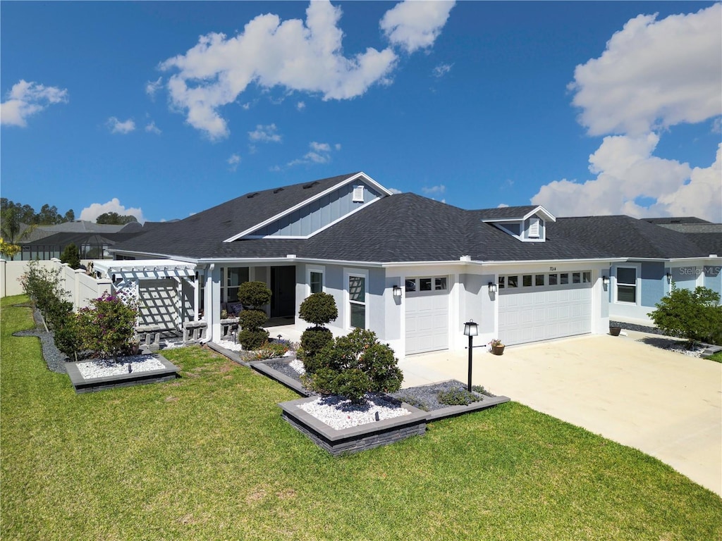 view of front of house featuring a front lawn, fence, stucco siding, a garage, and driveway