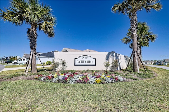 community / neighborhood sign with a lawn and a residential view