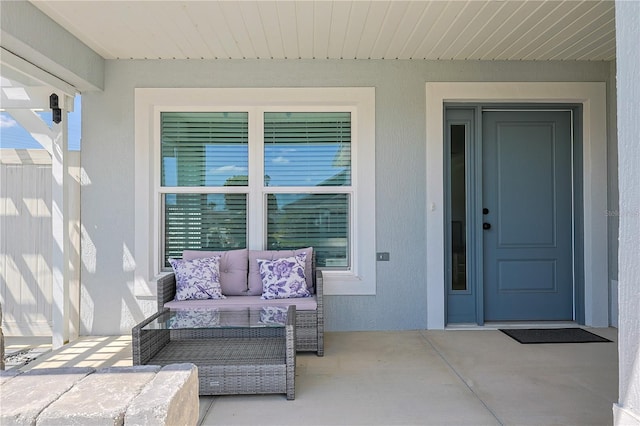7014 Elaine Ct, The Villages, FL 34762 - view of exterior entry featuring stucco siding, outdoor lounge area, and a patio area